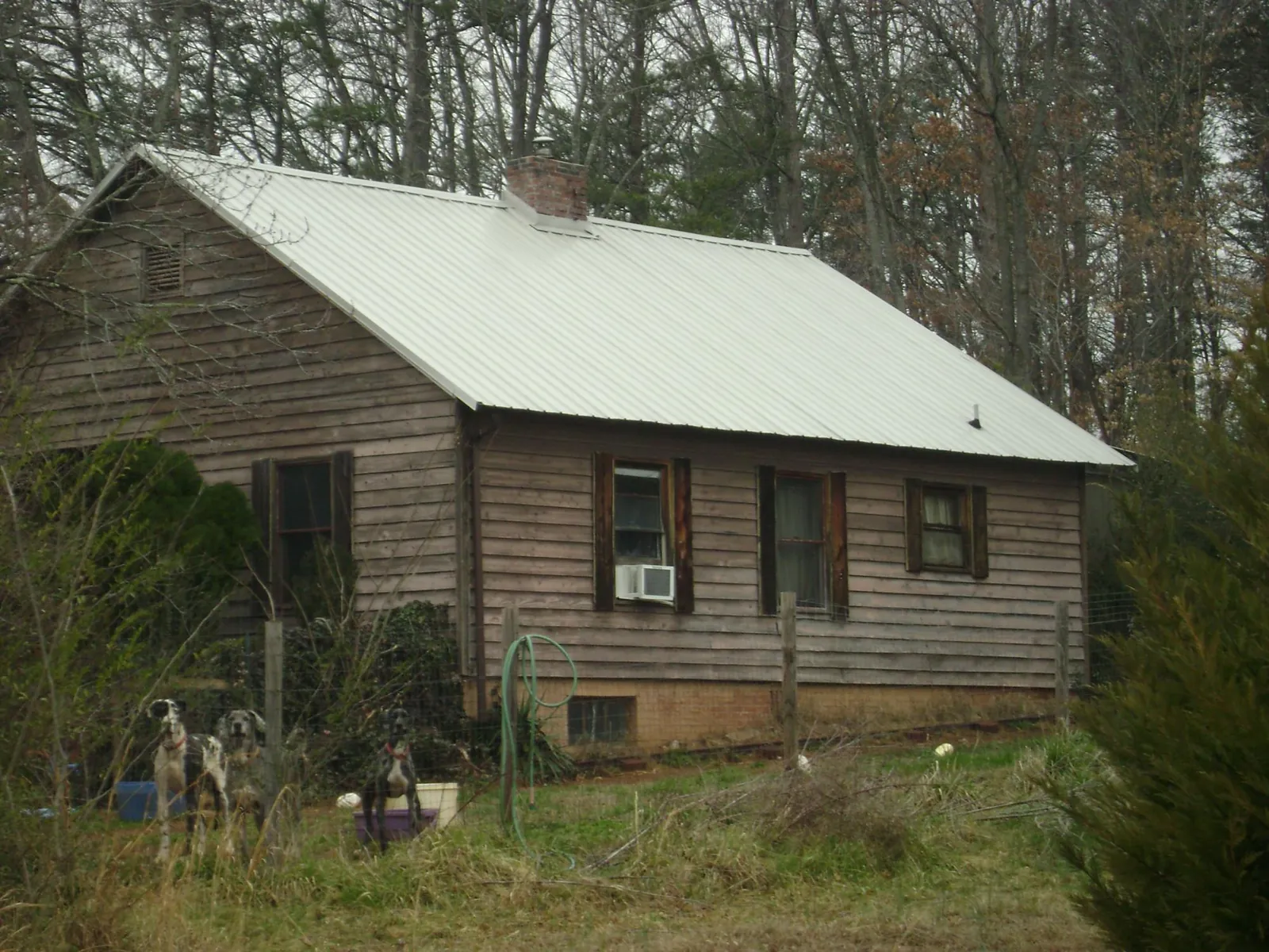 White metal roof on an old wood sided farmhouse, from a Metal Roof Installation job in Stafford